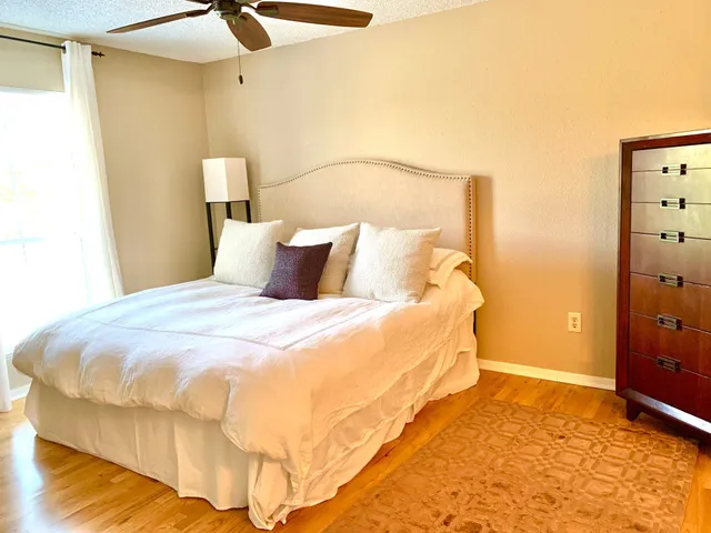 a bedroom with a bed and a ceiling fan