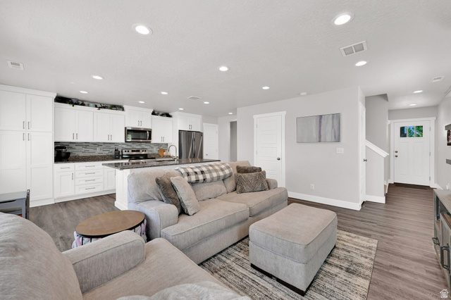 2777 West 4175th Street South, Unit 232 Roy, UT 84067 - Photo 4 of 27 Open-concept living space/kitchen featuring LVP flooring, recessed lighting, and white plantation shutters