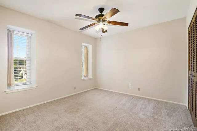 an empty room with closet and windows