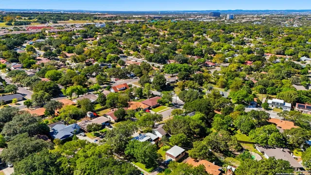an aerial view of residential houses with outdoor space and trees