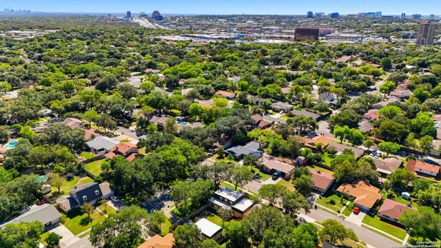 an aerial view of residential houses with outdoor space and trees