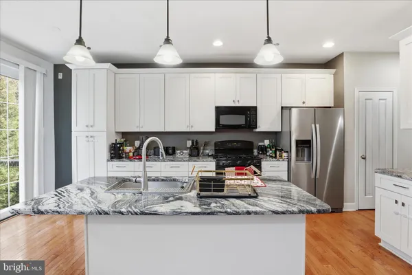 a kitchen with stainless steel appliances granite countertop a sink refrigerator and microwave