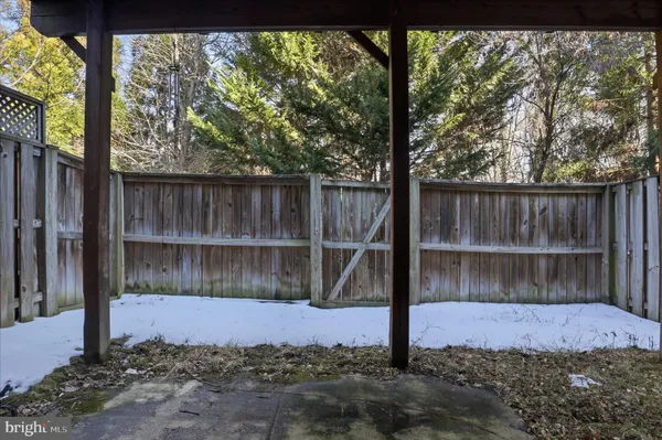 a view of a backyard with a large tree and wooden fence