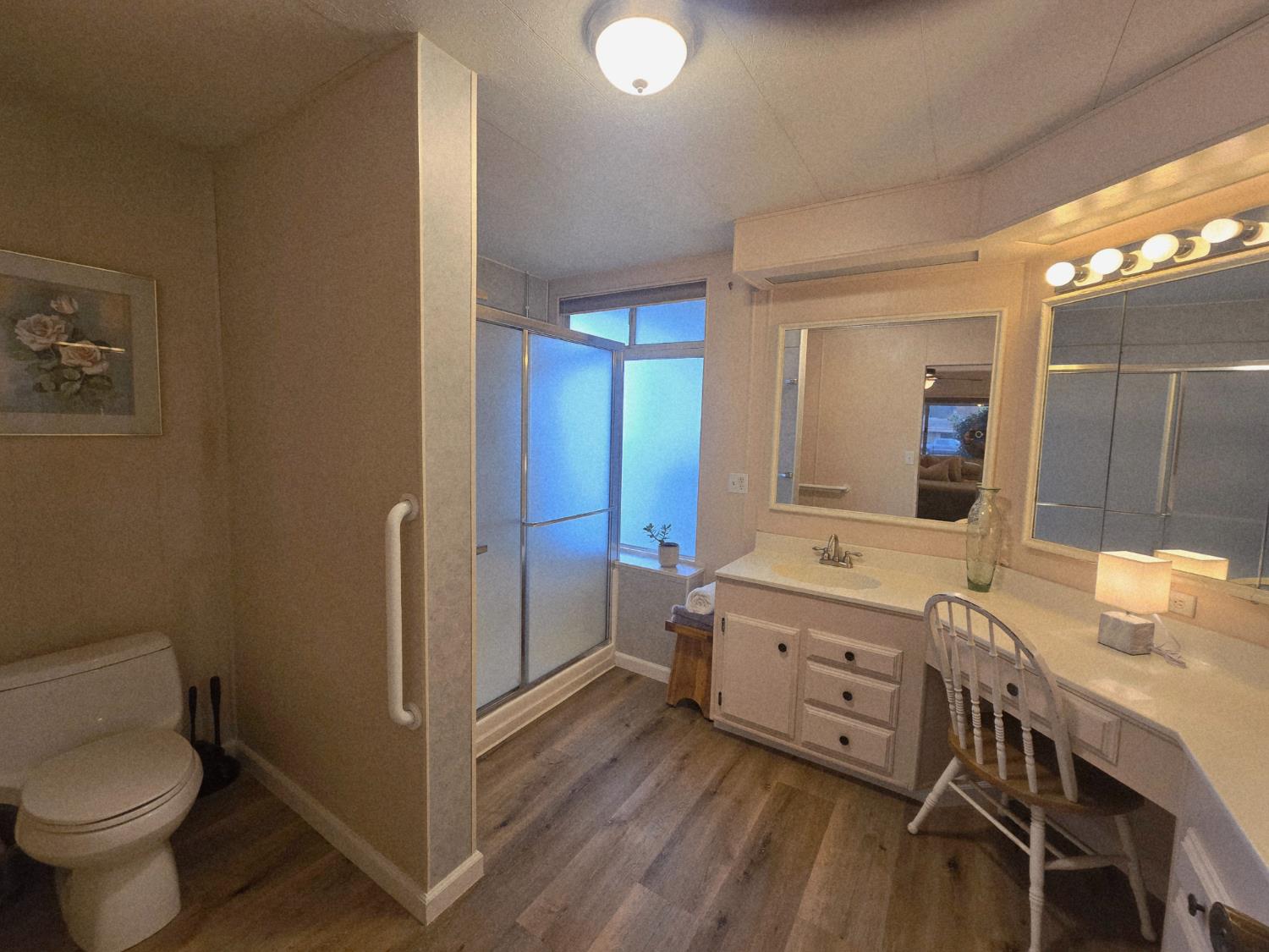 1300 West Olson Avenue, Unit 73 Reedley, CA 93654 - Photo 13 of 23 a bathroom with a granite countertop sink mirror vanity and toilet