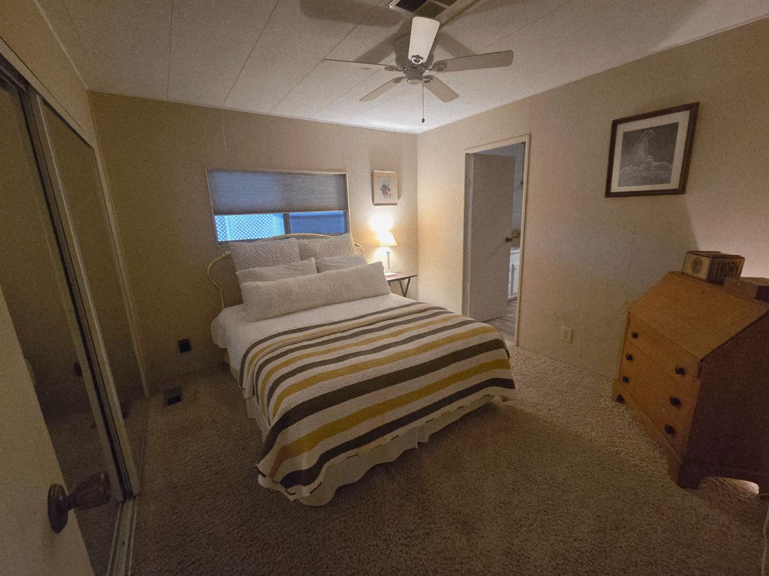 1300 West Olson Avenue, Unit 73 Reedley, CA 93654 - Photo 16 of 23 a bedroom with a bed and a chandelier