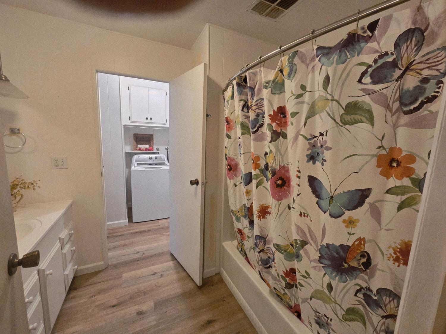 1300 West Olson Avenue, Unit 73 Reedley, CA 93654 - Photo 19 of 23 a bathroom with a bathtub and shower curtain