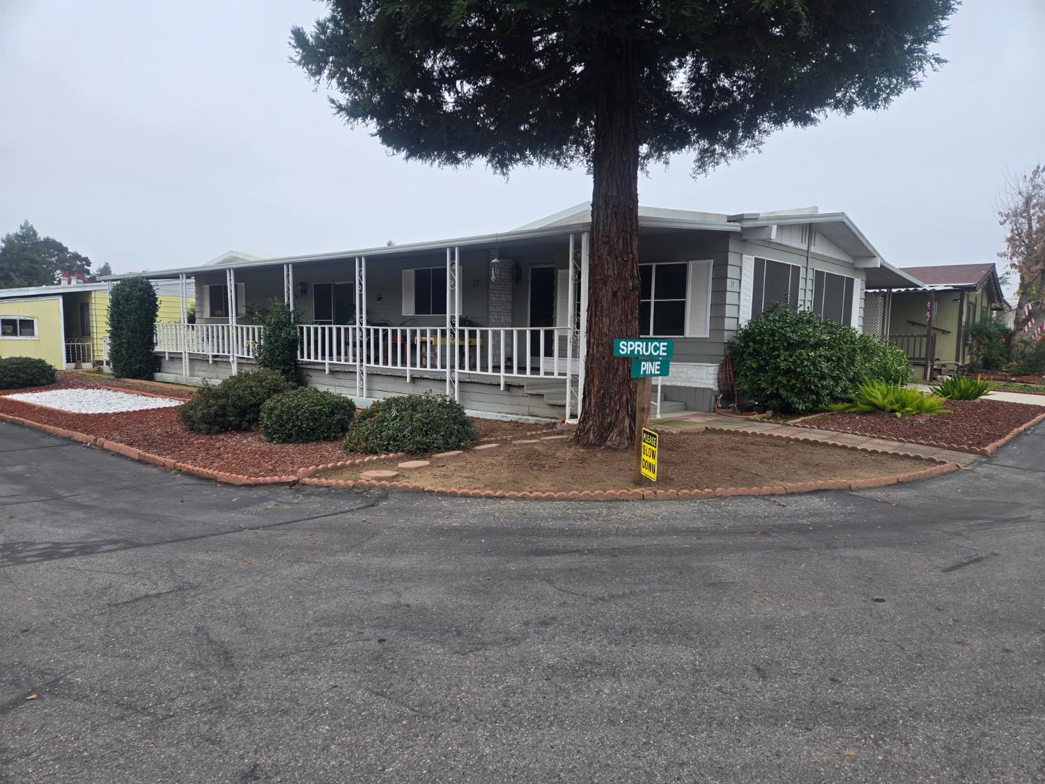 1300 West Olson Avenue, Unit 73 Reedley, CA 93654 - Photo 2 of 23 a front view of a house with a yard