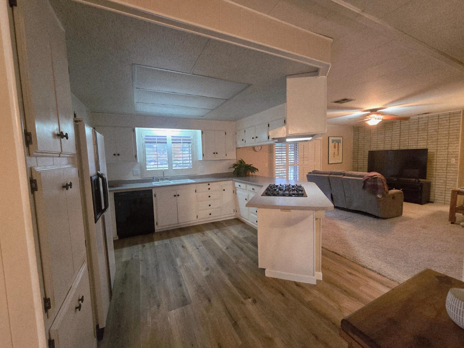 1300 West Olson Avenue, Unit 73 Reedley, CA 93654 - Photo 7 of 23 a large kitchen with a sink and a refrigerator