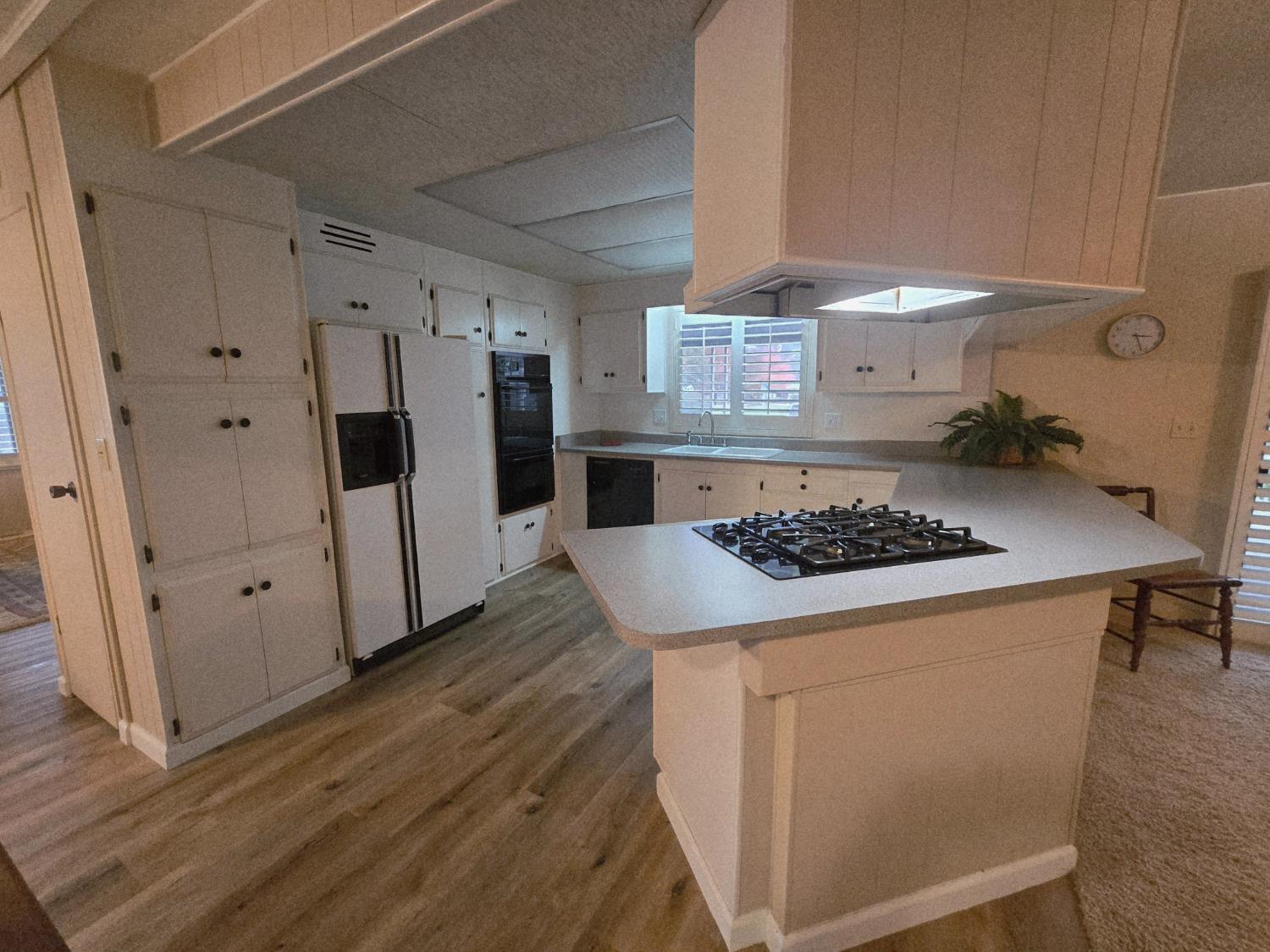 1300 West Olson Avenue, Unit 73 Reedley, CA 93654 - Photo 8 of 23 a kitchen with a counter and a stove top oven