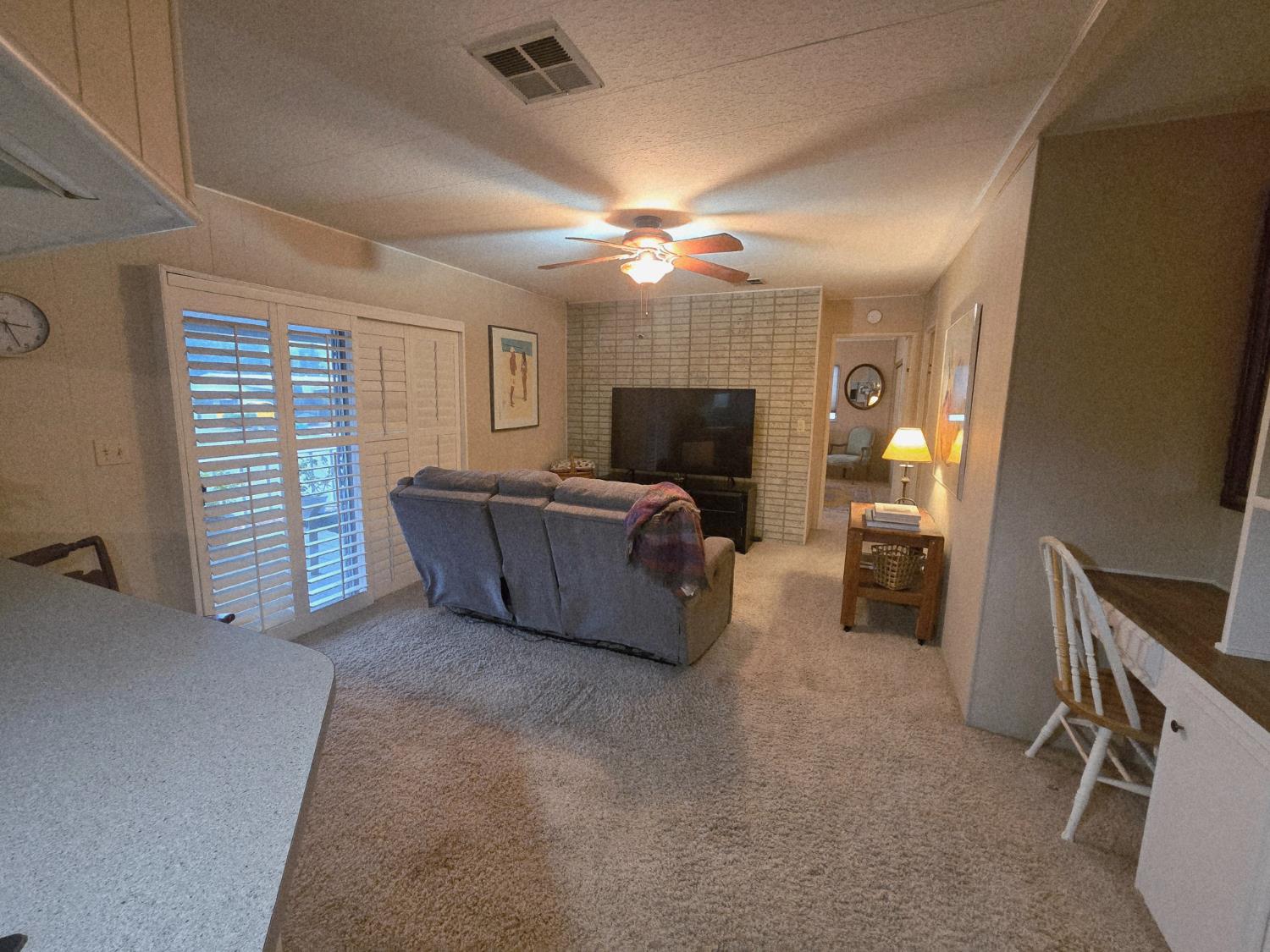 1300 West Olson Avenue, Unit 73 Reedley, CA 93654 - Photo 9 of 23 a living room with furniture and a flat screen tv