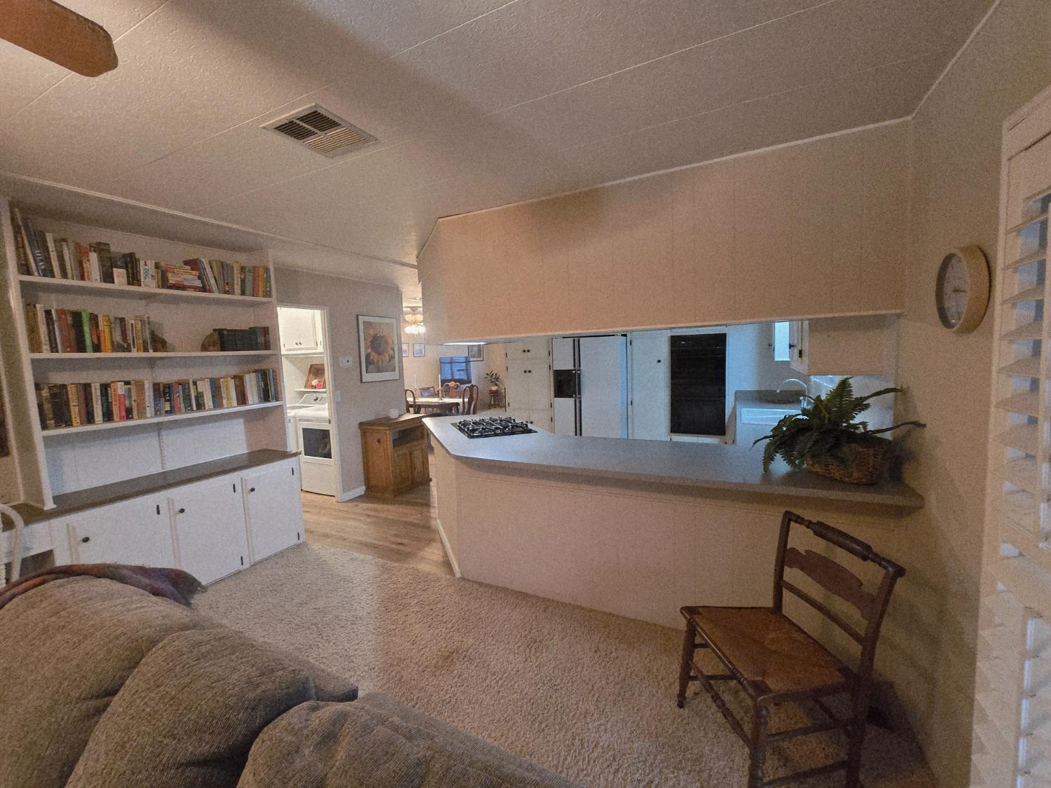 1300 West Olson Avenue, Unit 73 Reedley, CA 93654 - Photo 10 of 23 a living room with furniture and a book shelf