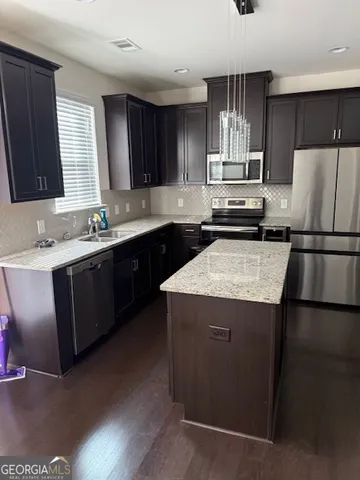 a kitchen with a sink a stove a refrigerator and cabinets
