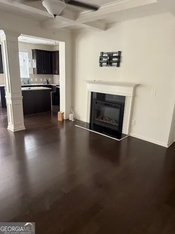 an empty room with wooden floor fireplace and a window