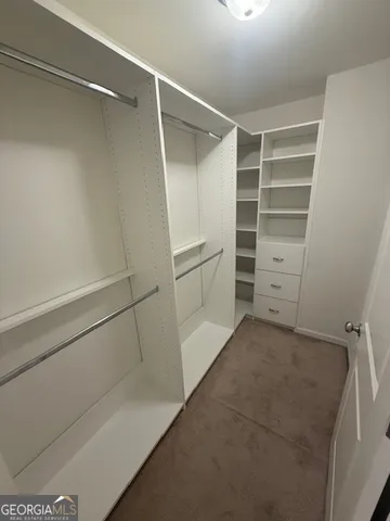 a view of walk in closet with empty racks