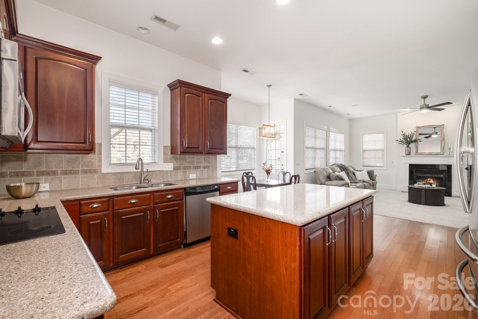 5019 Mesa Verde Road Charlotte, NC 28277 - Photo 12 of 40 a kitchen with stainless steel appliances granite countertop wooden cabinets a sink a stove a dining table and chairs
