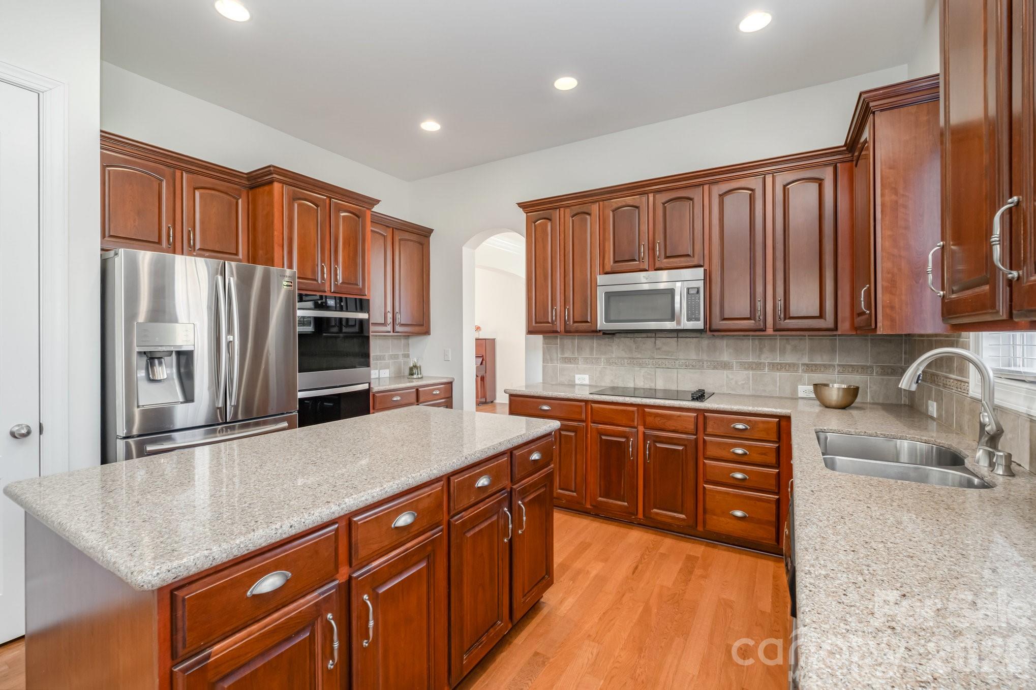 5019 Mesa Verde Road Charlotte, NC 28277 - Photo 14 of 40 a kitchen with stainless steel appliances granite countertop a sink stove microwave and refrigerator