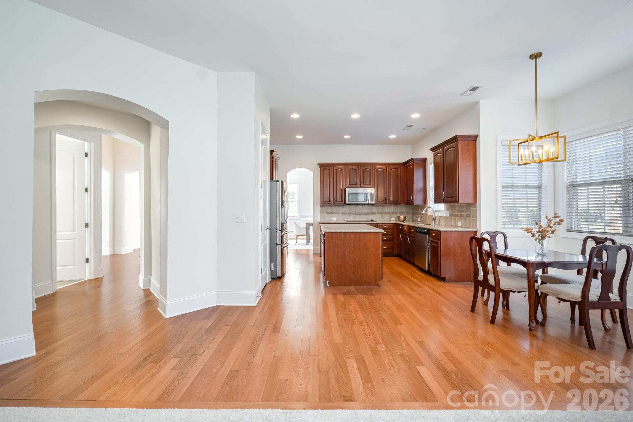 5019 Mesa Verde Road Charlotte, NC 28277 - Photo 15 of 40 a living room with stainless steel appliances kitchen island granite countertop wooden floor a dining table and chairs