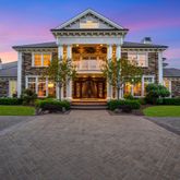 a front view of a house with a yard and potted plants