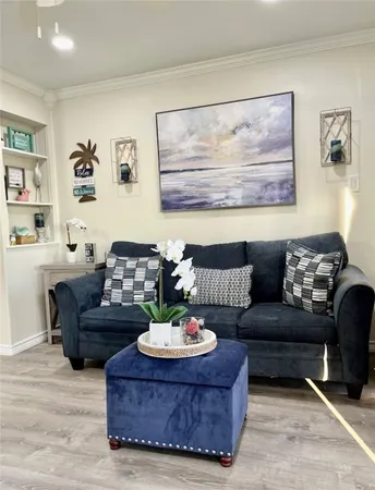 a living room with furniture and view of kitchen