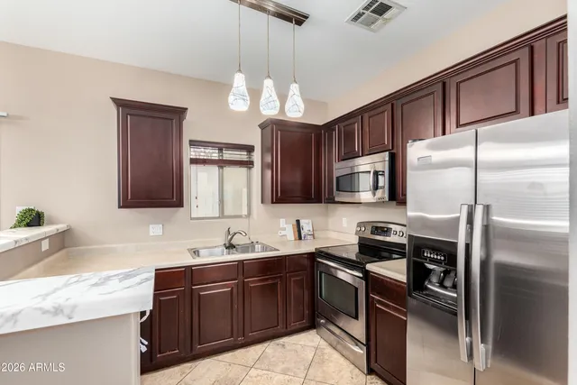 a kitchen with stainless steel appliances granite countertop a sink refrigerator and microwave
