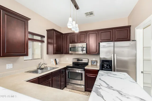 a kitchen with a refrigerator sink and wooden cabinets