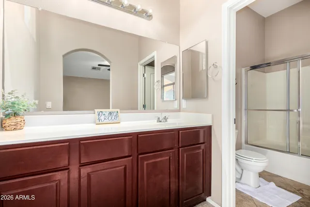 a bathroom with a granite countertop sink mirror and toilet