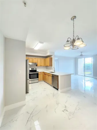 a kitchen with stainless steel appliances kitchen island granite countertop a stove a sink and a refrigerator