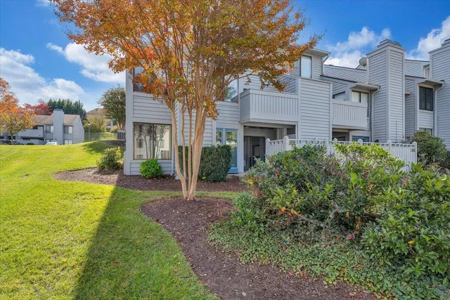 a view of a house with a big yard plants and large trees