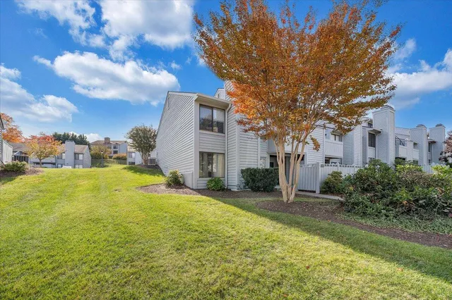 a view of a house with a yard and large tree