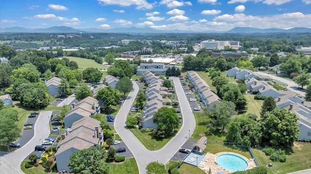 an aerial view of residential houses with outdoor space and trees