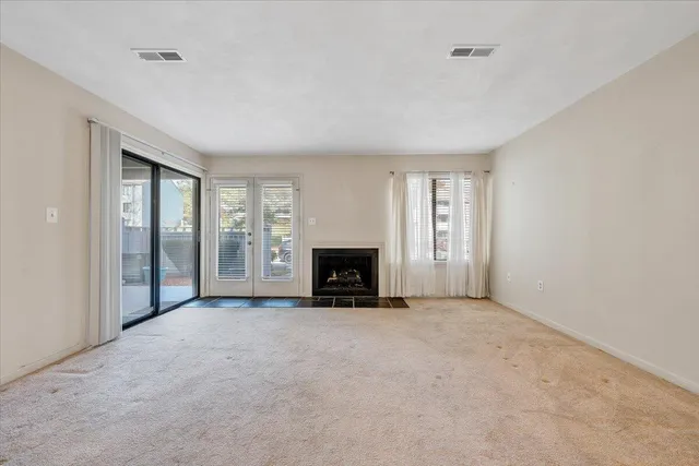 a view of an empty room with a fireplace and a window