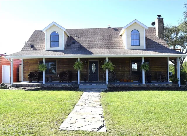 a view of a house with a garden and patio