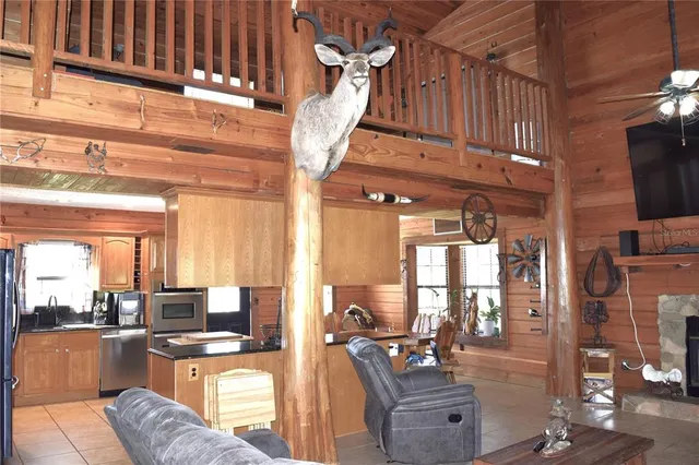 a living room with furniture a flat screen tv and floor to ceiling windows