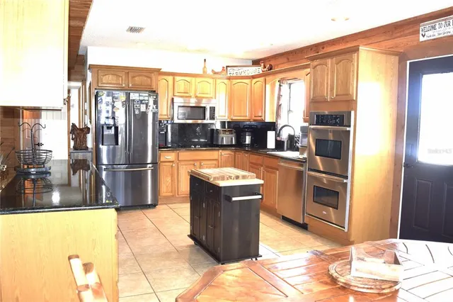 a kitchen with stainless steel appliances granite countertop a refrigerator and a stove
