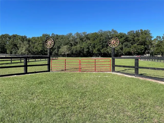 a view of a yard with wooden fence