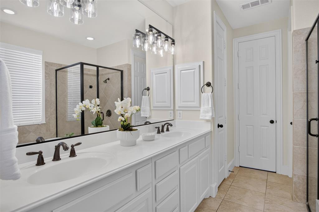 842 Sun Meadow Road Allen, TX 75013 - Photo 15 of 39 Double vanity with integrated sinks, white cabinetry, and bronzed fixtures