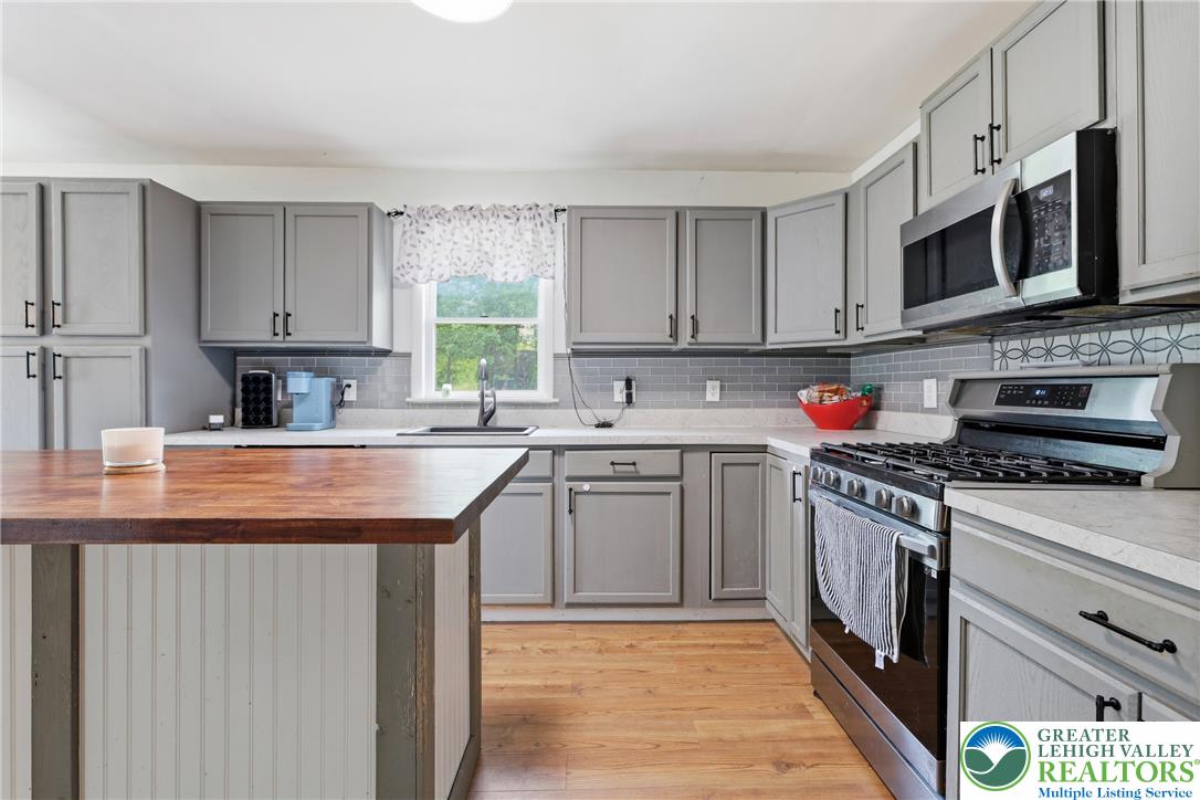 732 Bushkill Center Road Nazareth, PA 18064 - Photo 11 of 43 Well-appointed kitchen featuring light-toned cabinetry, an island with a wooden countertop, and sleek stainless steel appliances.