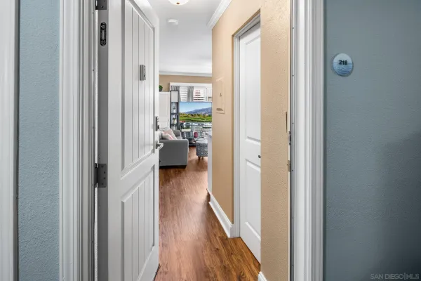 a view of a hallway with wooden floor windows and a livingroom