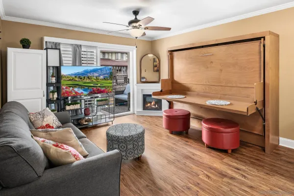 a living room with furniture a flat screen tv and a floor to ceiling window