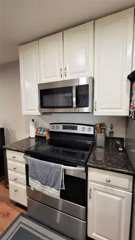 a kitchen with granite countertop a sink cabinets and stainless steel appliances