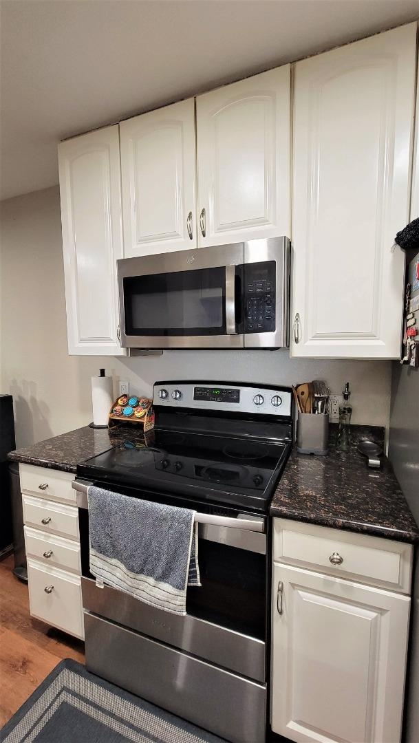 680 Dartmore Lane, Unit 259 Hayward, CA 94544 - Photo 22 of 25 a kitchen with granite countertop white cabinets and black appliances