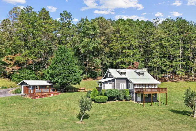 a front view of a house with a yard balcony and outdoor seating