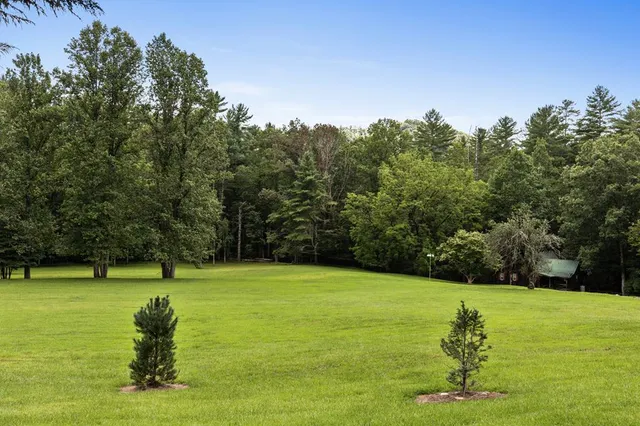 an aerial view of a houses with a lush green hillside