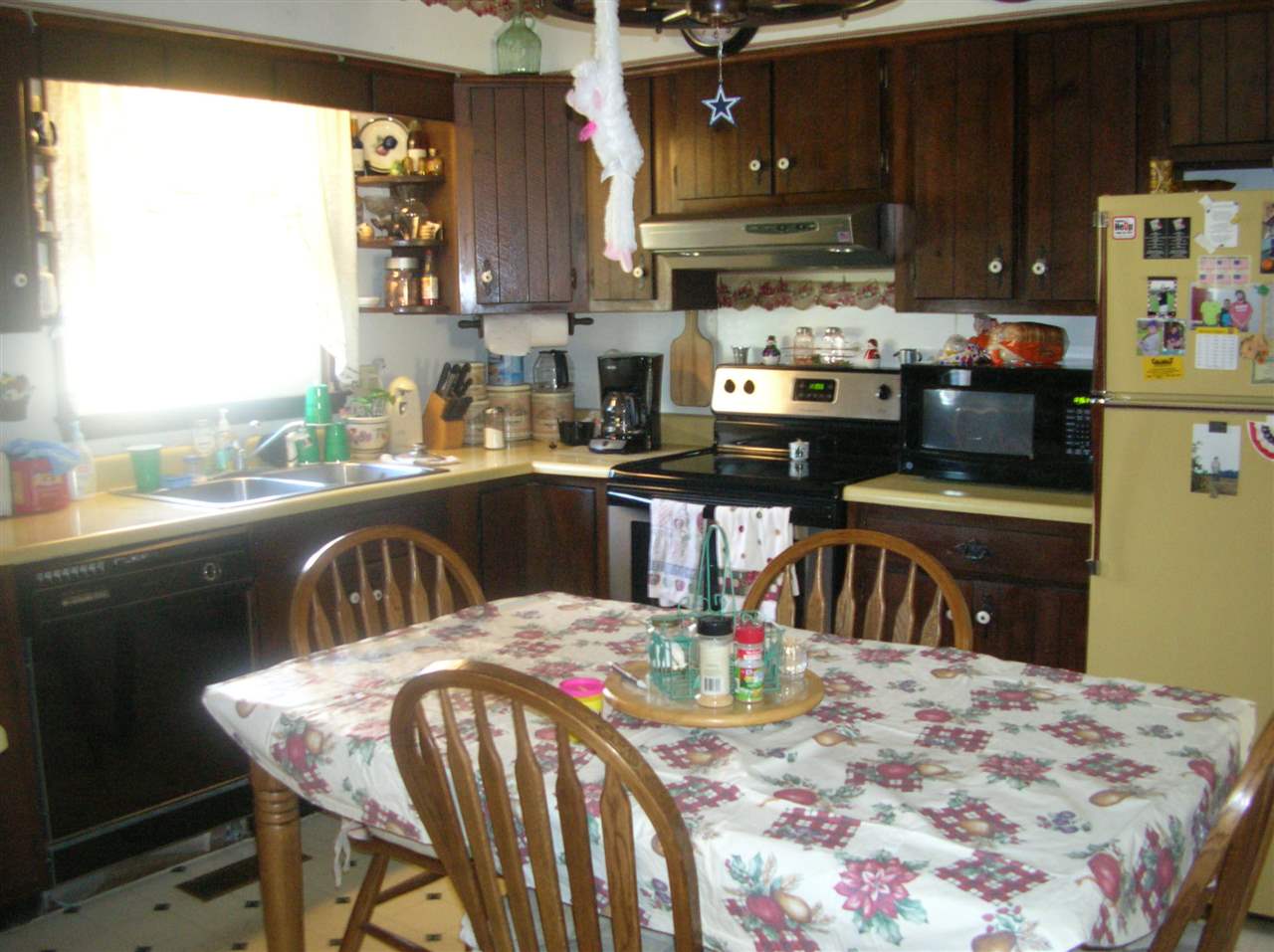 256 Kiddsville Road Fishersville, VA 22939 - Photo 7 of 13 a kitchen with stainless steel appliances granite countertop a sink a stove a refrigerator a dining table and chairs with wooden floor