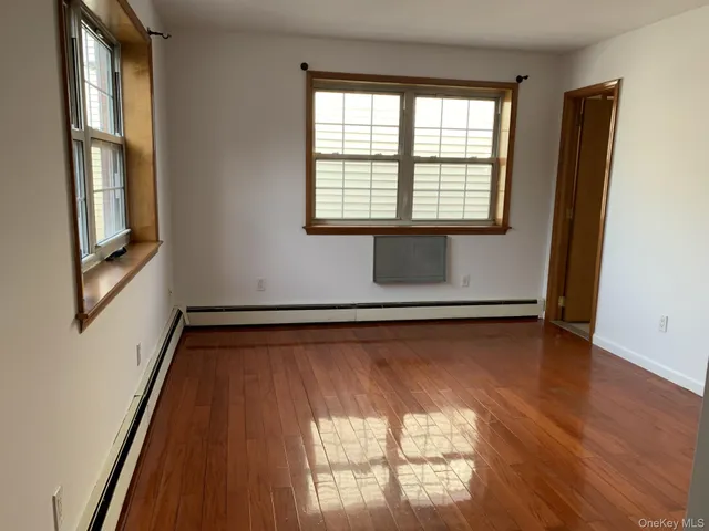 a view of a room with wooden floor and windows