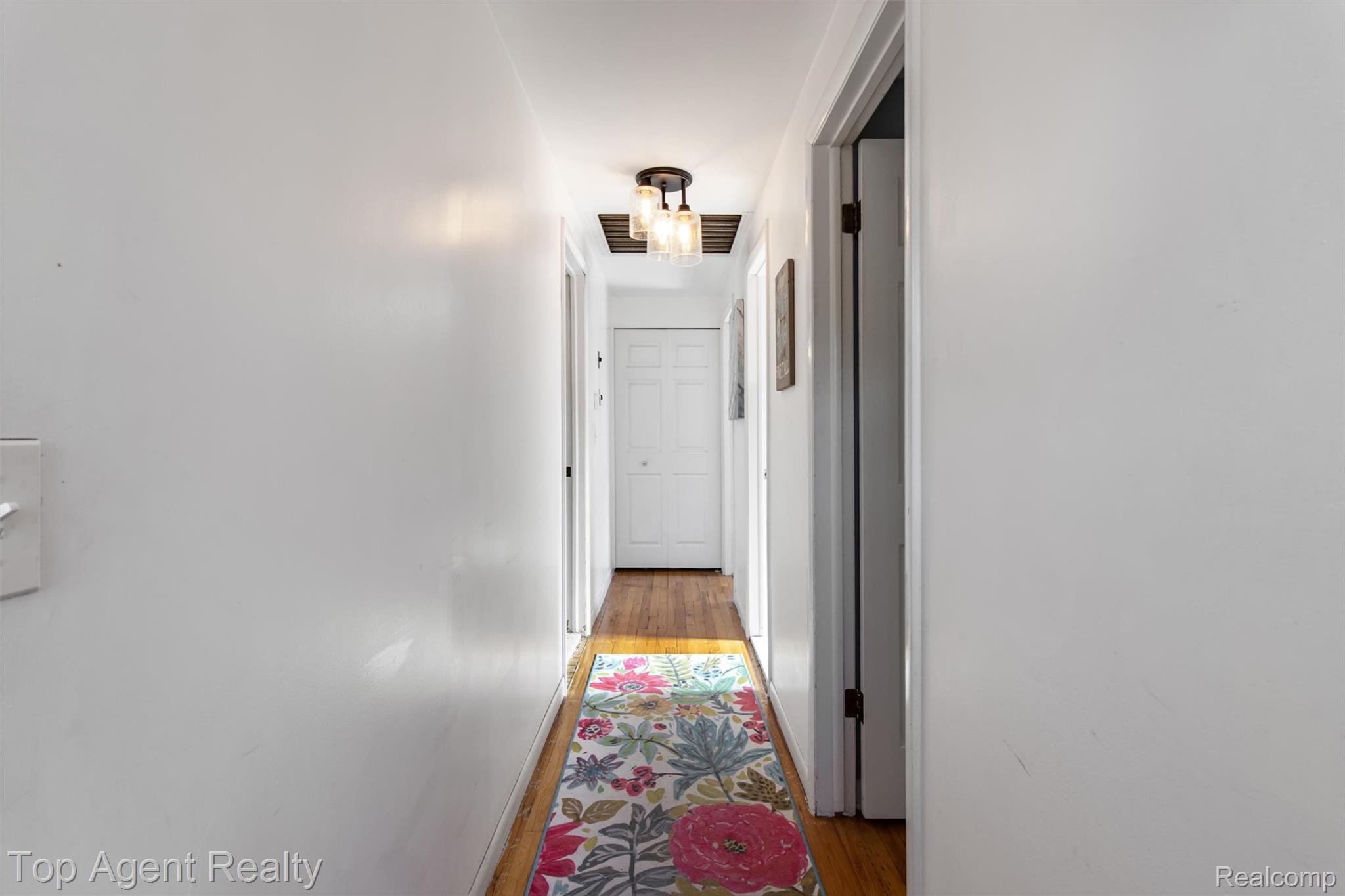32341 Woody Road Fraser, MI 48026 - Photo 17 of 47 Hallway featuring warm wood-finish flooring and a contemporary ceiling light fixture