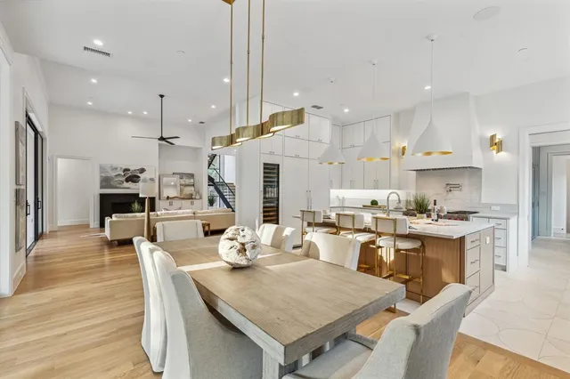 a kitchen with a table chairs wooden floor and stainless steel appliances
