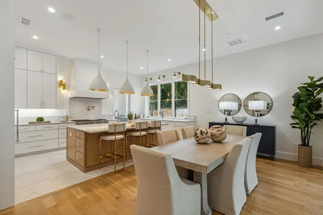 a kitchen with a stove a sink a kitchen island with wooden cabinets and floor