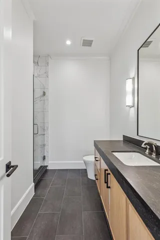 a bathroom with a sink a toilet and shower