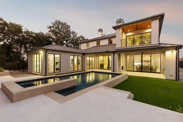 a view of a house with swimming pool and sitting area